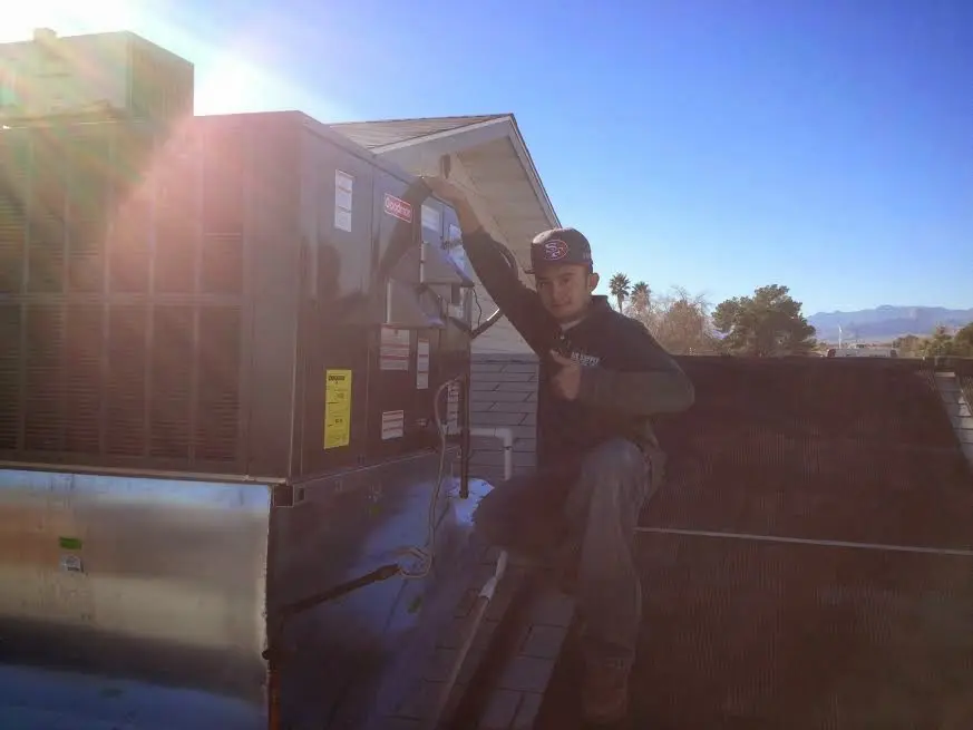 HVAC technician performing AC Tune-Up on a rooftop unit in Pequannock